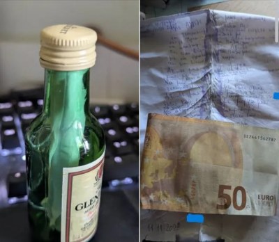 Μπουκάλι με γράμμα και 50 ευρώ σε φόντο πληκτρολογίου.