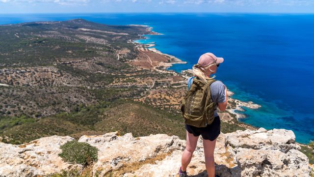 unrecognizable traveler on cliff admiring seascape